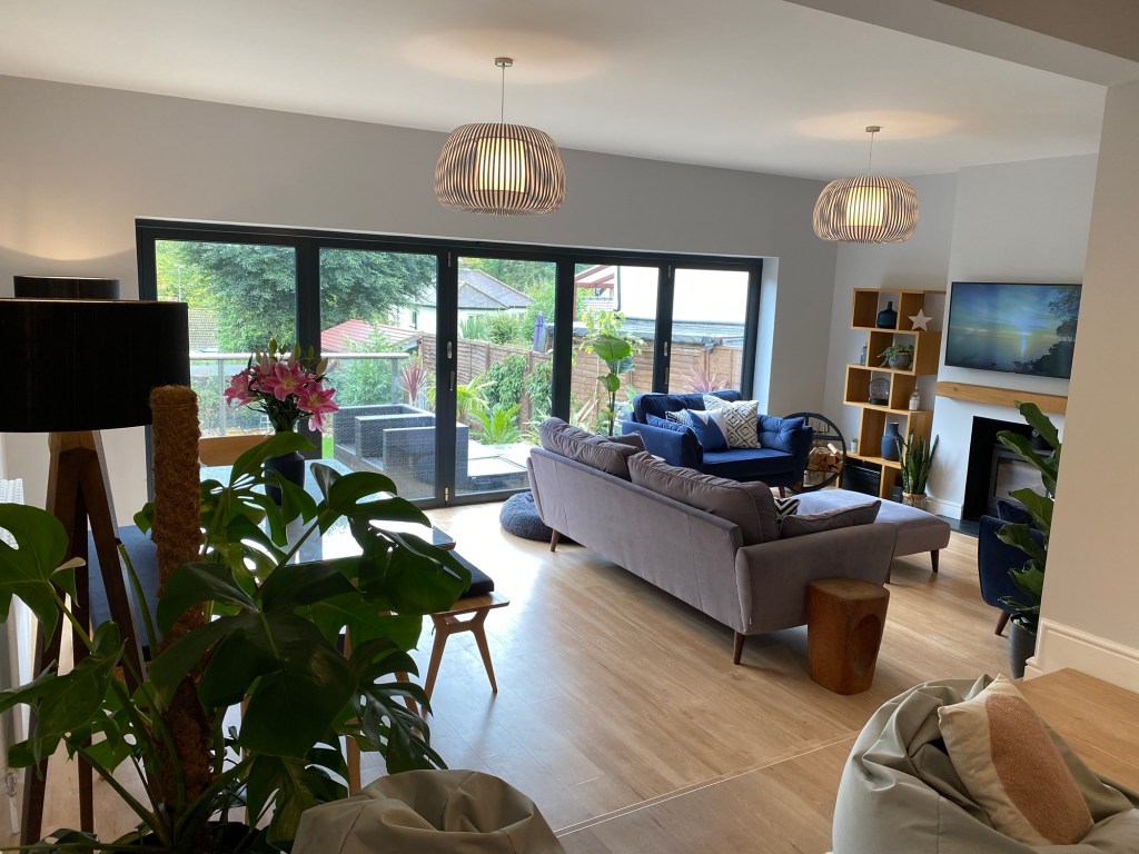 Our open-plan living room, with hard wood-effect flooring and doors onto the garden